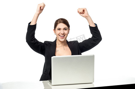 兴奋的员工摄影照片_兴奋的女商人举起双臂