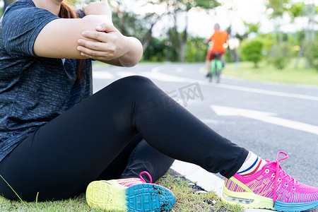 亚洲女性在公园外慢跑和跑步时手臂和肘部疼痛。