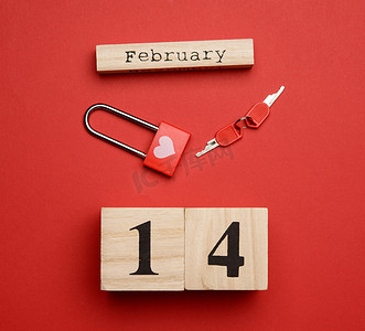 日期为 2 月 14 日的木制日历和背景上带钥匙的锁