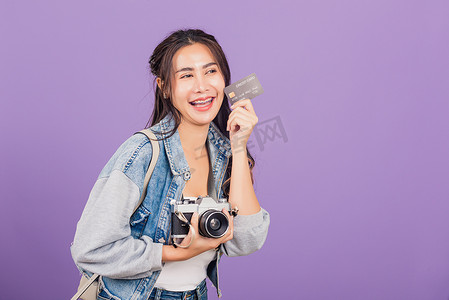 拿着借记信用卡银行和复古古董相机的女人兴奋地微笑着摄影师