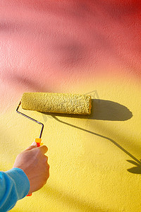 用滚筒画家画笔手绘黄色墙壁