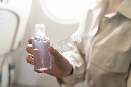 女人在飞机上消毒双手，涂上凝胶酒精