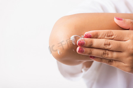女人在手肘上涂乳液