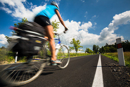 骑自行车在乡下公路的女性骑自行车者