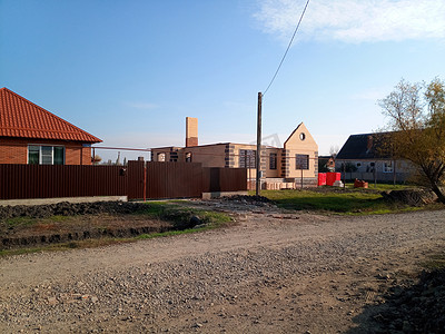 有橙色屋顶和棕色栅栏的新房子。