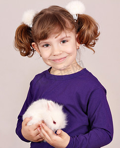 拿着可爱的矮小兔子的小女孩