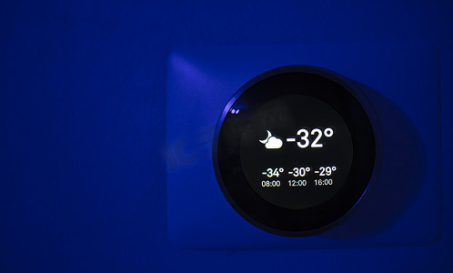 室内温度低摄影照片_夜间数字恒温器显示冬季室外温度为 -31 摄氏度