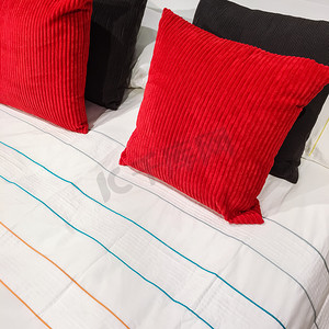 带红色和黑色平绒靠垫的床