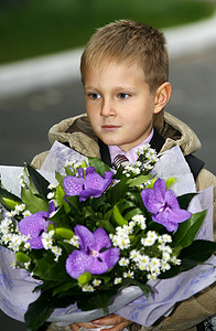 拿着花的男孩摄影照片_拿着花束的男孩