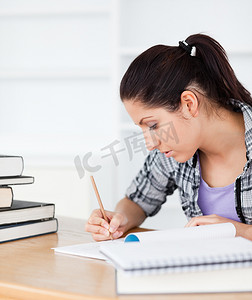 年轻学生在她的练习册上写作