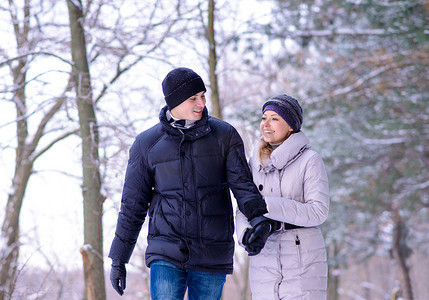 美丽的冬天二摄影照片_年轻美丽的夫妇在下雪的冬天在户外微笑
