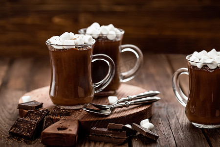 热巧克力摄影照片_木质背景中带棉花糖的热巧克力甜点