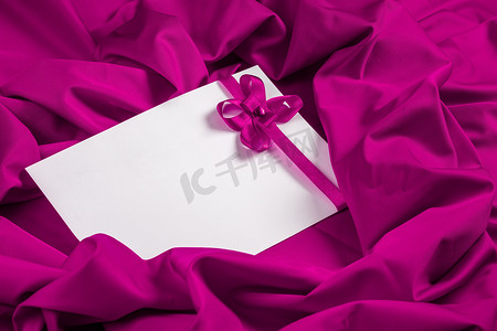 紫色织物上带有心形和丝带的爱心卡片