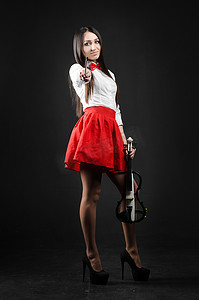 黑色背景中一个微笑的女孩拿着小提琴站着