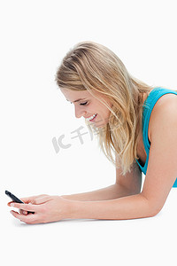一个微笑的女人正在她的手机上发短信