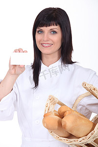 名片餐饮摄影照片_展示名片的女面包师