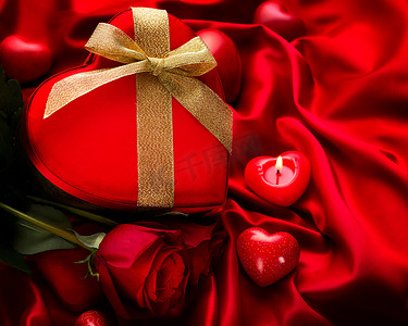 红丝绸摄影照片_红丝绸上的情人节红耳礼物和红玫瑰花