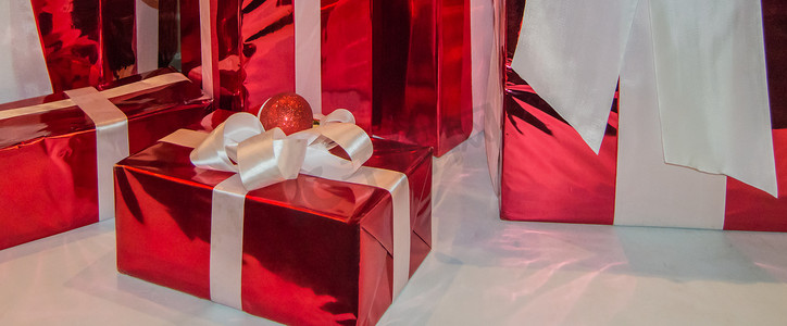 新年横幅，水平背景，白色背景上用白色丝带装饰的红色节日礼盒