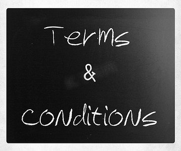 条款和条件摄影照片_“条款和条件”在黑板上用白色粉笔手写