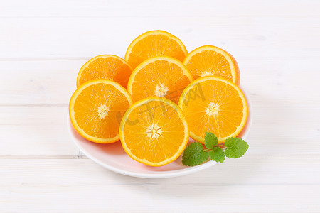 切橙子摄影照片_一堆切半的橙子
