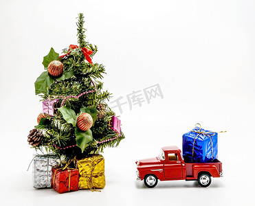 红色复古汽车玩具带着一个盒子，里面有圣诞树的礼物