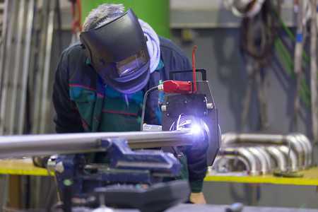 焊接机摄影照片_产业工人设置轨道焊接机。
