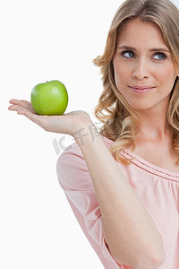 移门l绿色花纹摄影照片_拿着一个绿色苹果的微笑的少妇