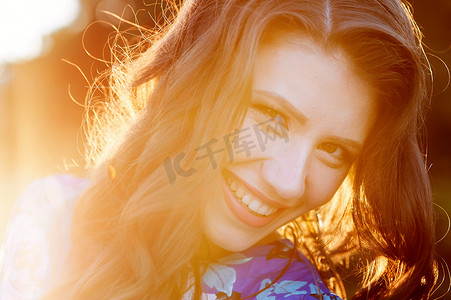 发光的太阳摄影照片_发光的太阳背景下快乐的年轻女人特写