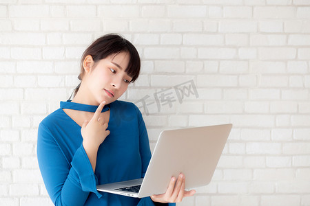 思考方式摄影照片_美丽的亚洲年轻女性嬉皮士使用工作笔记本电脑思考