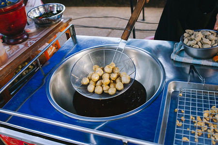 民间菜摄影照片_烹饪 在热油锅中炸鱼丸。