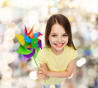 电人玩具摄影照片_带着彩色风车玩具微笑的孩子