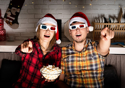 戴 3D 眼镜的年轻夫妇圣诞节在家看电影