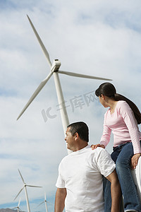 父亲带着女儿坐在风电场涡轮机附近的汽车上