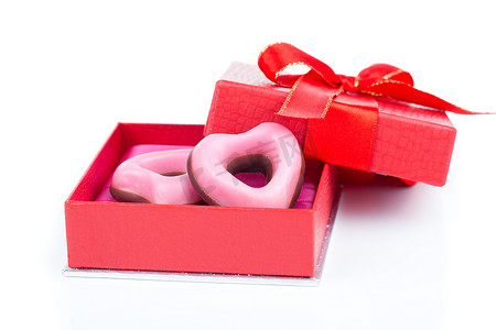 红色可爱摄影照片_情人节的粉红色心形饼干，红色礼物，白色背景