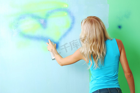 女人粉刷墙壁