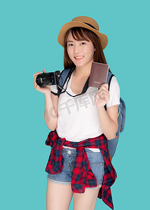 相机旅行摄影照片_美丽的亚洲年轻女性肖像戴着帽子，微笑着自信地拿着护照和相机，在假期孤立的蓝色背景下带着护照和相机旅行，模范旅游亚洲女孩对旅程感到高兴。