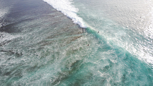 冲浪者在乌鲁瓦图巴厘岛的海滩上冲浪