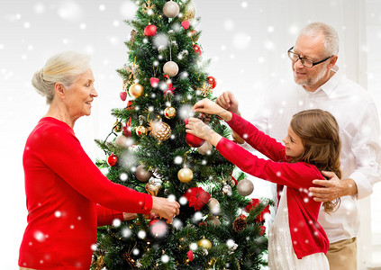 微笑的家庭在家里装饰圣诞树