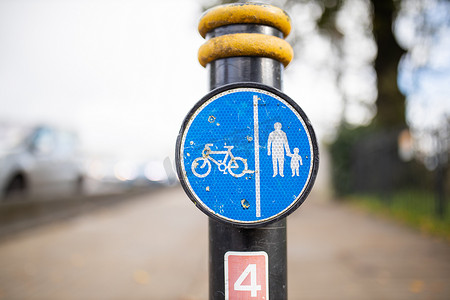 指示图标摄影照片_杆子上的蓝色标志指示行人和骑自行车的人的路径