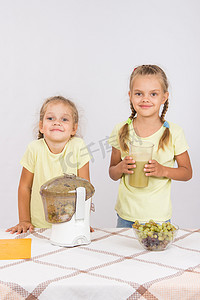 两个女孩在榨汁机里榨果汁