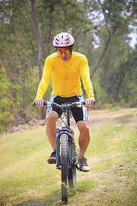 丛林扁平化摄影照片_男子和山地自行车在丛林轨道上骑行用于自行车 spo