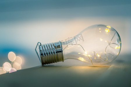 想法和创新：带 LED 的灯泡躺在一张木桌上。