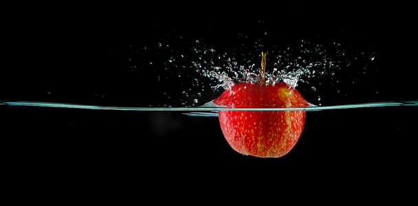 苹果在黑色背景的水中飞溅
