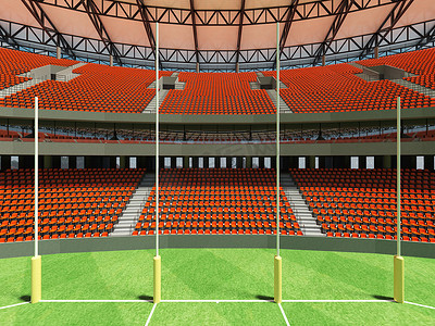 垂直俯拍足球场摄影照片_美丽的现代圆形澳式足球场，设有橙色座椅和贵宾包厢