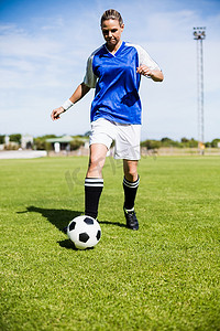运动袜摄影照片_练习足球的女足球运动员