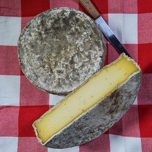 市场摊位摄影照片_在市场摊位上出售的法国托姆奶酪