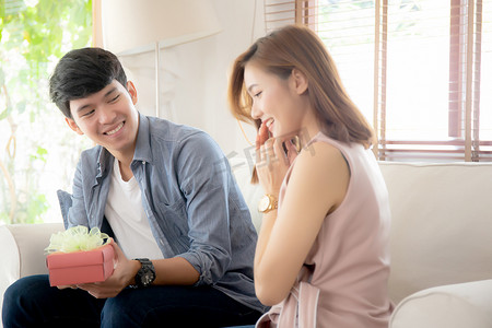 年轻的亚洲夫妇一起庆祝生日，亚洲男人送礼