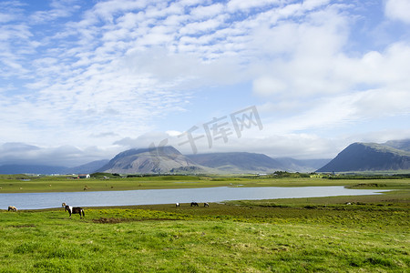 蓝色为背景摄影照片_以山为背景的美丽湖泊，冰岛，美好的夏天