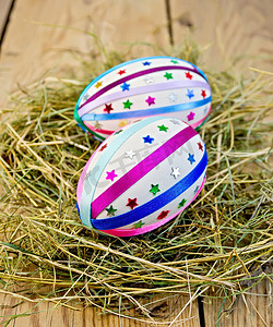 干草中带丝带和亮片的复活节彩蛋