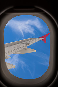 窗蓝天摄影照片_俯瞰飞机机翼的飞机窗户。